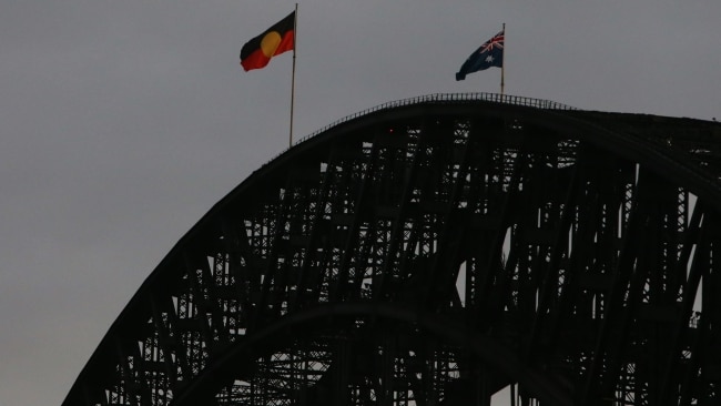 The Aboriginal flag is seen alongside the Australian flag on top of the Sydney Harbour Bridge on January 26. Picture: Lisa Maree Williams/Getty Images