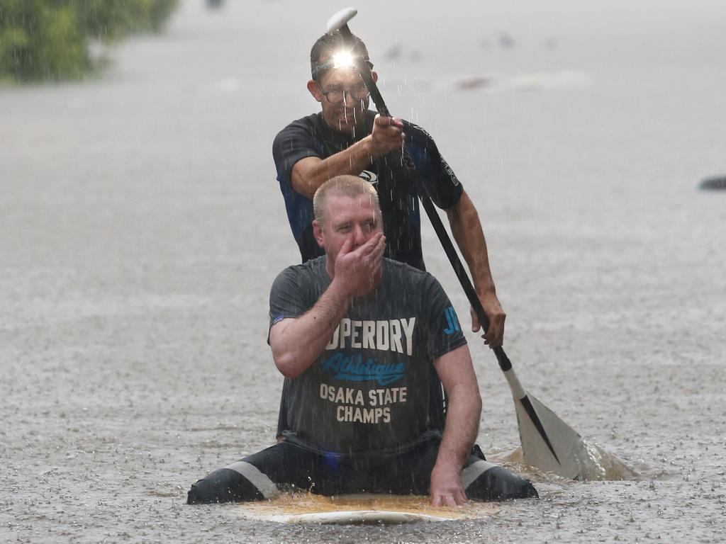 Windsor resident Dean Muller rescues Corey Gibson from flood waters on Victoria St, Windsor. Photo: Anthony Reginato