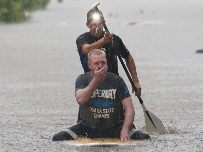 Windsor resident Dean Muller rescues Corey Gibson from flood waters on Victoria St, Windsor. Photo: Anthony Reginato