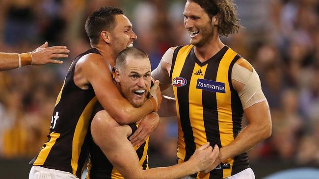 Jarryd Roughead mobbed by teammates Jack Gunston and Tyrone Vickery after kicking his first goal in his comeback against Essendon in Round 1 since being cleared of cancer. Picture: Michael Klein