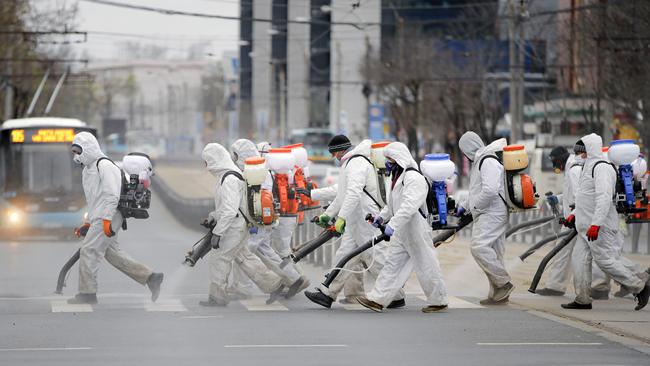 Council workers wearing protective outfits disinfect part of the Romanian capital of Bucharest. Picture: AP