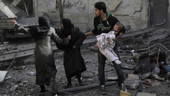 Syrians run for cover following Syrian government air strikes on the Eastern Ghouta rebel-held enclave of Douma, on the outskirts of the capital Damascus in 2018. Picture: AFP