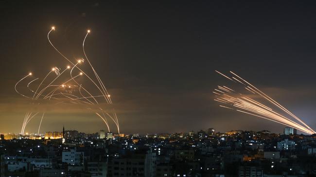 The Israeli Iron Dome missile defence system, left, intercepts a rocket, right, fired by Hamas towards southern Israel in May. Picture: AFP