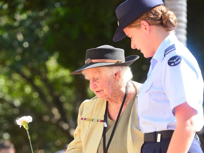 Leaving tributes ... Townsville’s Victory In the Pacific Parade where Peg Kimlin of Laidley is helped as she lays a flower. Picture: Scott Radford-Chisholm