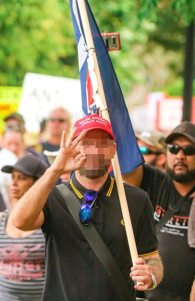 The man makes an OK sign at an anti-Covid vaccine mandate rally in Darwin last year.