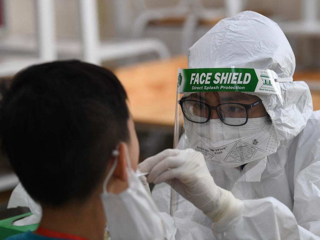 A health worker wearing personal protective equipment (PPE) conducts a Covid-19 coronavirus swab test on a student at the Vinschool private school in Hanoi on May 22, 2021. Picture: Nhac Nguyen / AFP