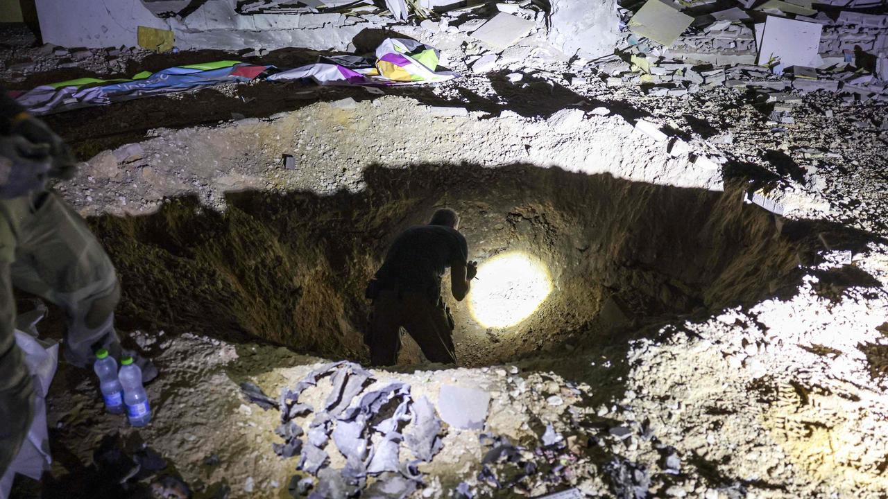 A crater left by an exploded projectile at a heavily-damaged school building in Israel's southern city of Gedera. Picture: Menahem Kahana / AFP