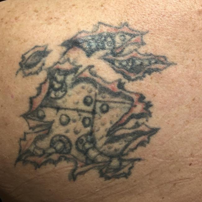 Chris (Junior) Davies says his kids call his tattoo the “Swiss Cheese Dragon”. It’s supposed to be like Arnold Schwarzenegger in Terminator. We we think it is more like the bastard offspring between a Pizza Shape and a dragon. Or just a sketch of a Mitchell St grog spew.
