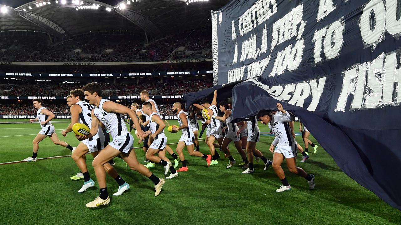 Carlton run through their banner for another Thursday night game. Picture: Mark Brake