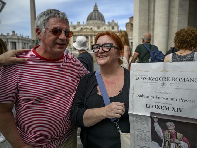 People hold a copy of the Vatican newspaper L' Osservatore Romano with the front-page picture of newly elected Leo XIV. Picture: Getty Images