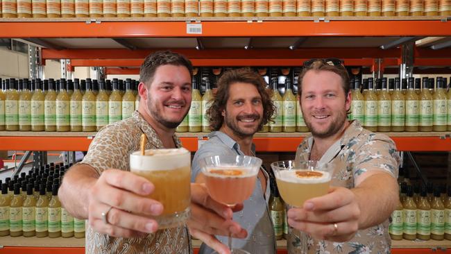 Mr Consistent owners, Jarrad Bell, Michael Sebire and Jeremy Davidson, toast the success of their ready made cocktails mix, at the company factory at Burleigh. Picture: Glenn Hampson