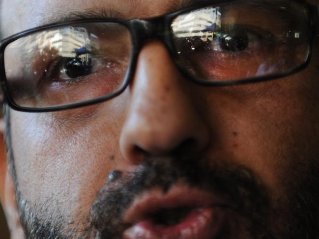 ***FILE*** A April 18, 2011 file image of Sheikh Man Haron Monis (centre), believed to be the gunman inside the Lindt Cafe in Martin Place, Sydney. Up to a dozen hostages are inside a cafe in Sydney's Martin Place with an Islamic flag pressed up against the shop window. Muslim cleric Man Haron Monis speaks to the media as he leaves the Downing Centre after a pre-trial hearing of his case, Monday, April 18, 2011. Monis is accused of sending offending letters to the families of soldiers killed in Afghanastan. (AAP Image/Dean Lewins) NO ARCHIVING