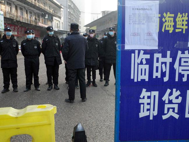 Security guards standing in front of the closed Huanan wholesale seafood market. Picture: AFP