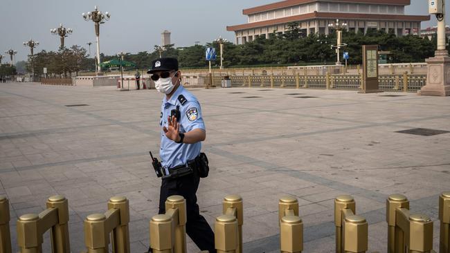 A police officer gestures as he secures an area outside Beijing's Tiananmen Square on World Press Freedom Day on May 3, 2020.