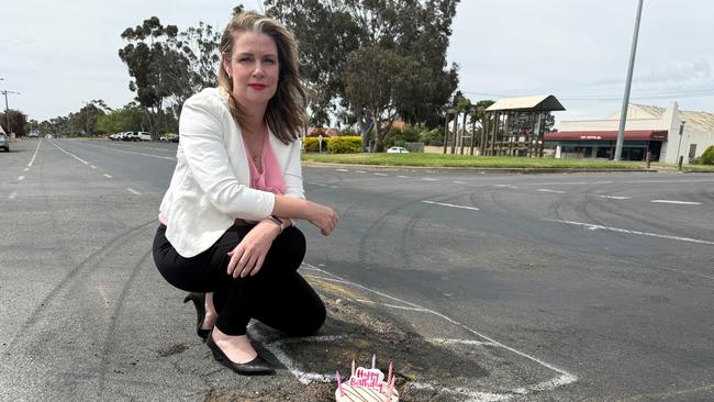 Member for Lowan Emma Kealy at a Rupanyup pothole with a birthday cake marking another year without it being repaired.