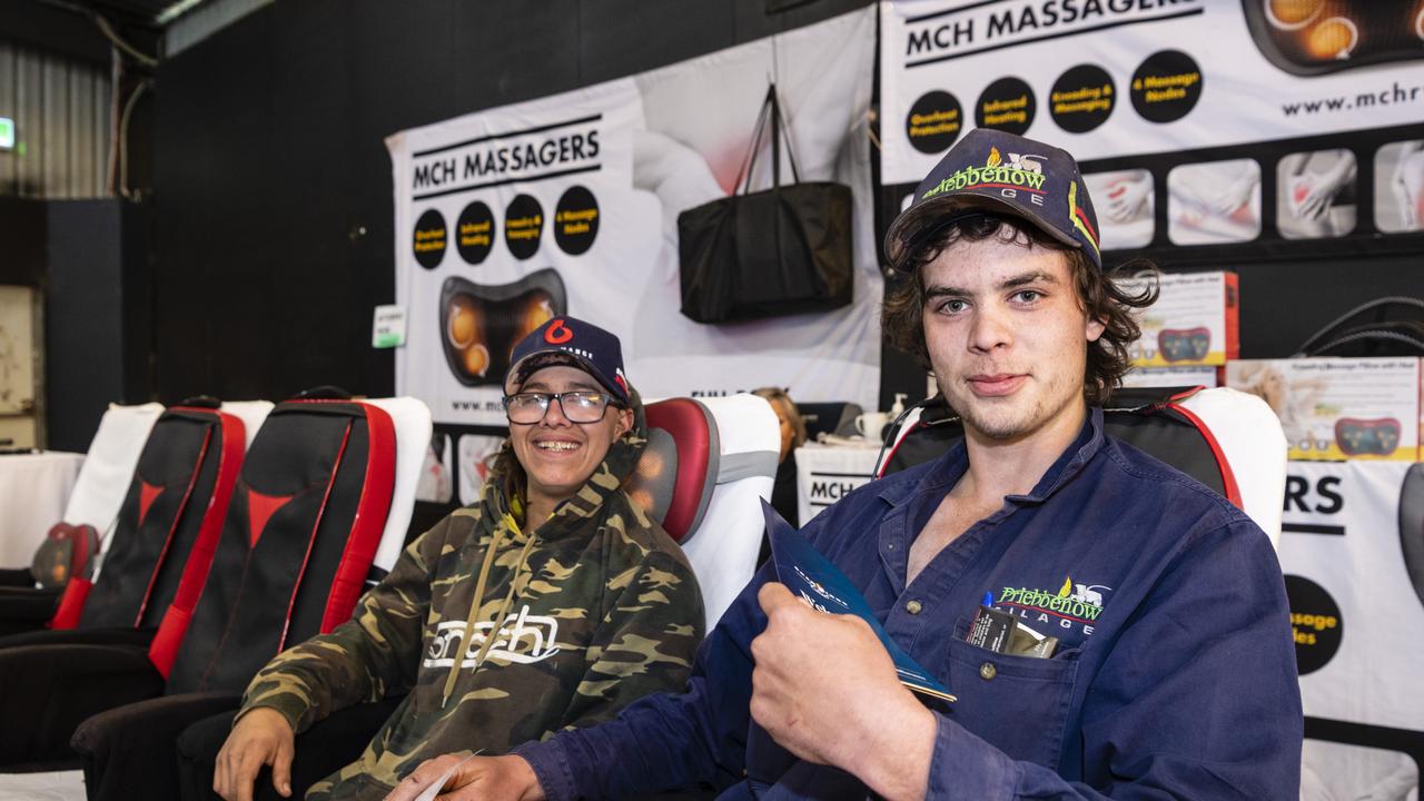 Eric Cassells (left) and Connor Reed get comfortable trying out the MCH Massagers on show at the Queensland Outdoor Adventure Expo at the Toowoomba Showgrounds, Saturday, July 30, 2022. Picture: Kevin Farmer