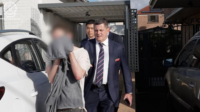 The man covered his face as he was arrested. Picture: NSW Police