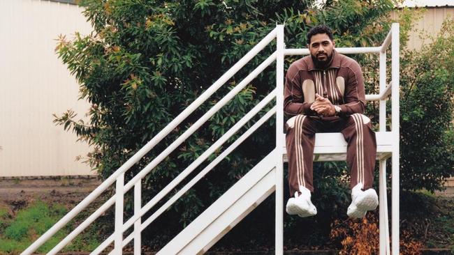 Mailata wears tracksuit jacket, pants, both by Song For The Mute x Adidas; sneakers, by Balenciaga; stainless steel and yellow gold Spirit Zulu watch, by Longines. Photography by Levon Baird