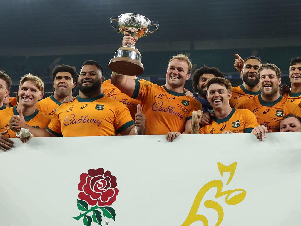 Australia's captain Harry Wilson holds the Ella-Mobbs Trophy as Australia's players pose after their win in the Autumn Nations Series International rugby union test match between England and Australia at the Allianz Stadium, Twickenham in south-west London, on November 9, 2024. Australia won the game 42-37. (Photo by Adrian Dennis / AFP)