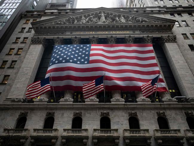 (FILES) In this file photo the US flag is seen at the New York Stock Exchange (NYSE) on April 30, 2020 in New York City. - Wall Street stocks tumbled in early trading May 4, 2020, with airline shares taking a major hit after Warren Buffett said he liquidated his holdings in major US carriers. About 15 minutes into trading, the Dow Jones Industrial Average stood at 23,383.10, down 1.4 percent.The broad-based S&P 500 dropped 1.0 percent to 2,801.24, while the tech-rich Nasdaq Composite Index shed 0.6 percent to 8,558.01. (Photo by Johannes EISELE / AFP)