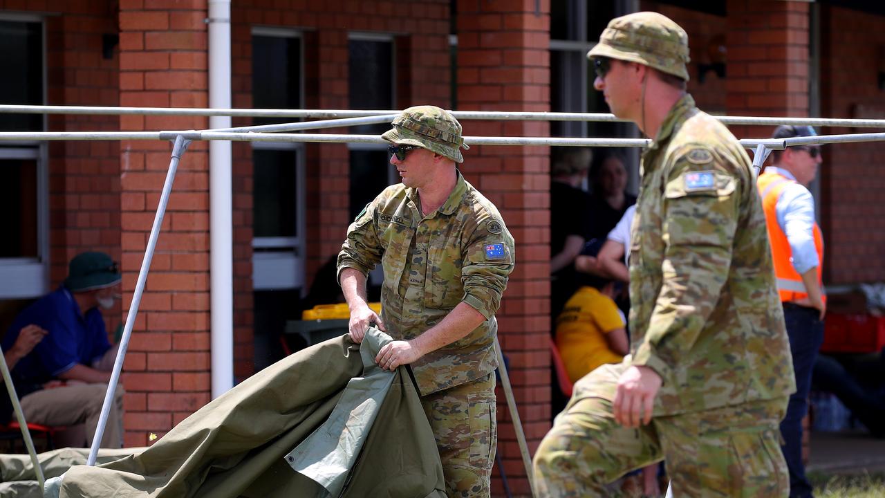 Members of the ADF start erecting tents outside the evacuation centre in Coraki. Picture: Toby Zerna