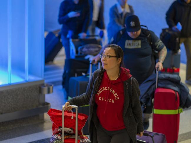 People arrive to LA International Airport from a flight serving Wuhan to face screening. Picture: AFP