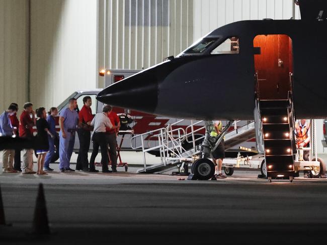 Medical personnel and visitors gather at the nose of a transport plane carrying Otto Warmbier before he is transferred to an ambulance at Lunken regional airport on June 13. Picture: AP Photo/John Minchillo