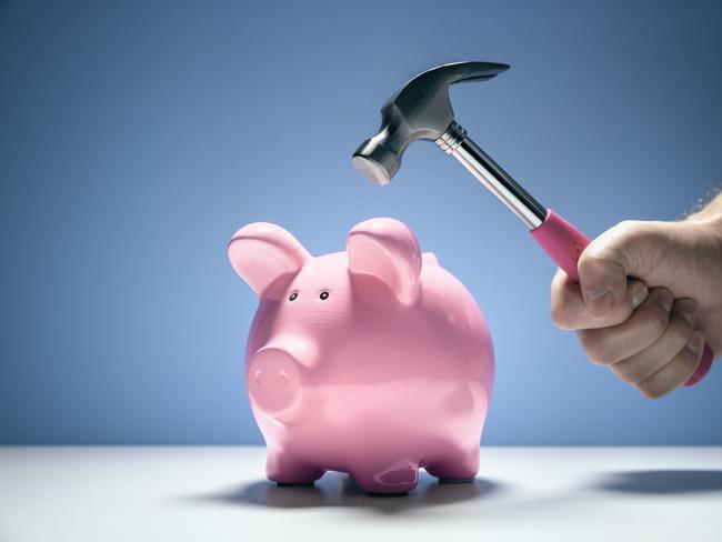 Pink piggy bank money box and hand with hammer about to hit and smash to get at savings, saving withdrawing superannuation generic