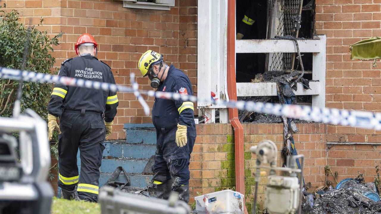 Firemen throw out burnt rubble at the scene. Picture: NewsWire / Simon Bullard.