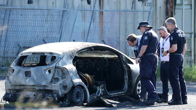 A car, which had been fully engulfed by flames is assessed by detectives after a body was found inside. Picture: Liam Kidston