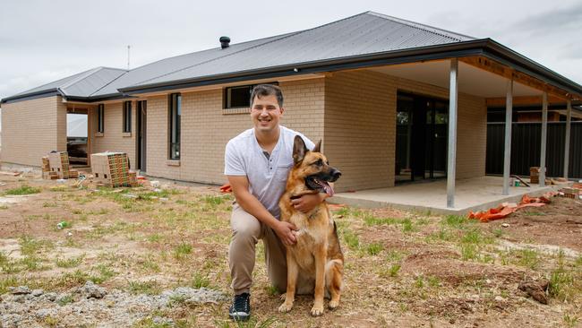 Benjamin Wong and dog Asia at his partly built home in Adelaide in October. He was among the first successful recipients of the HomeBuilder grant. Picture: Matt Turner