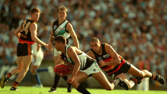 Crow Andrew McLeod tackles Port’s Peter Burgoyne in the first Showdown at Football Park.