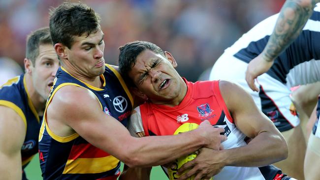 Adelaide’s Mitch Grigg tackles Melbourne’s Neville Jetta in 2014. Picture: Simon Cross