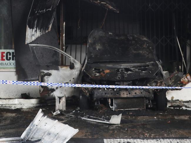 A car was used to ram the front door of this tobacco shop in Altona before the vehicle was set on fire. Picture: David Crosling