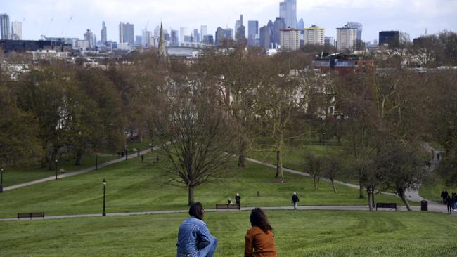 A couple look over London from a deserted Primrose Hill. Picture: AP.