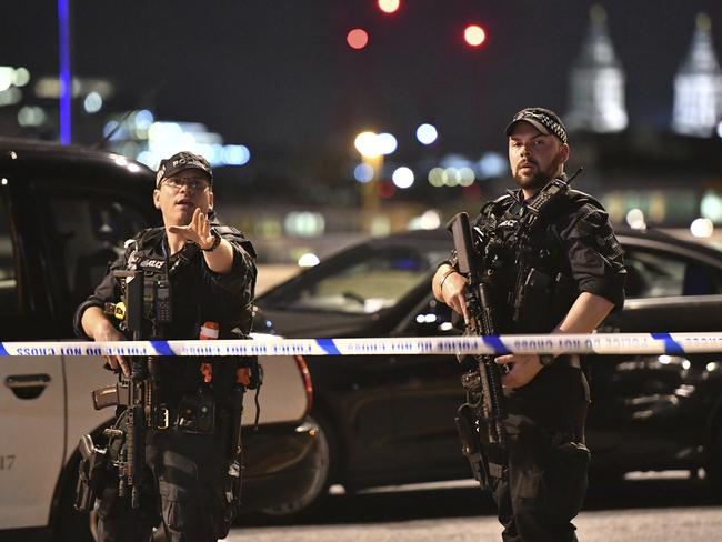 Armed Police officers stand guard on London Bridge in central London. Picture: Dominic Lipinski/PA via AP