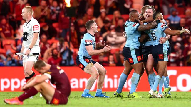 A disconsolate Maroons captain Daly Cherry-Evans as the Blues celebrate their series win Picture: Getty Images