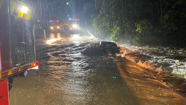 NSW Rural Fire Service firefighters from Otford and Helensburgh rescue a person trapped on the roof of their vehicle in fast flowing flood waters in Sydney's south. Picture: NSW RFS