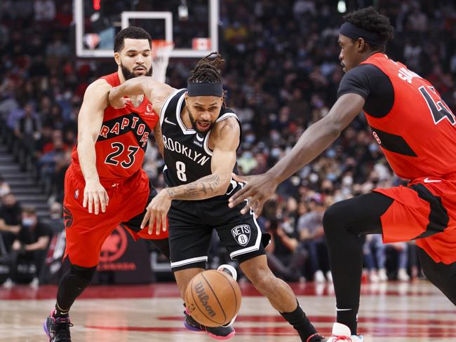 TORONTO, ON - NOVEMBER 07: Patty Mills #8 of the Brooklyn Nets dribbles his way through Fred VanVleet #23 and Pascal Siakam #43 of the Toronto Raptors during the first half of their NBA game at Scotiabank Arena on November 7, 2021 in Toronto, Canada. NOTE TO USER: User expressly acknowledges and agrees that, by downloading and or using this Photograph, user is consenting to the terms and conditions of the Getty Images License Agreement. (Photo by Cole Burston/Getty Images)