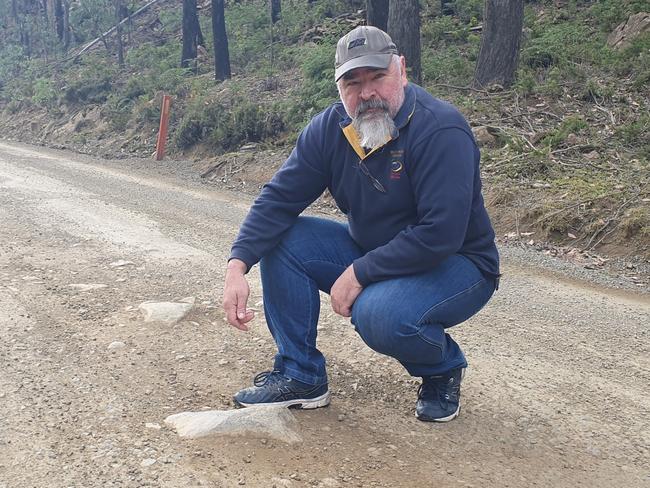 Bronte Park shop owner Shane Hedger shows how bad the state of the Marlborough Rd is, by pointing out a big rock in the middle of one of its sections. Picture: Supplied