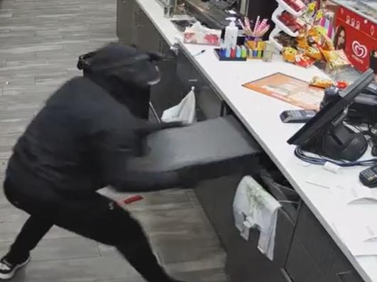 A fully black-clad and disguised armed robber has made off with the cash drawer in a calculated early morning armed robbery in Sydney's west. The knife-wielding person robber a service station in the suburb of Guilford about 4am on Sunday. Picture: Channel 9