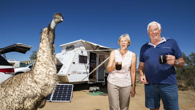 Grey Nomads Monika and Richard Gould from Victoria share a cup of tea with a curious emu at their campsite at the Apex Riverside Park outside of Longreach. Photo Lachie Millard