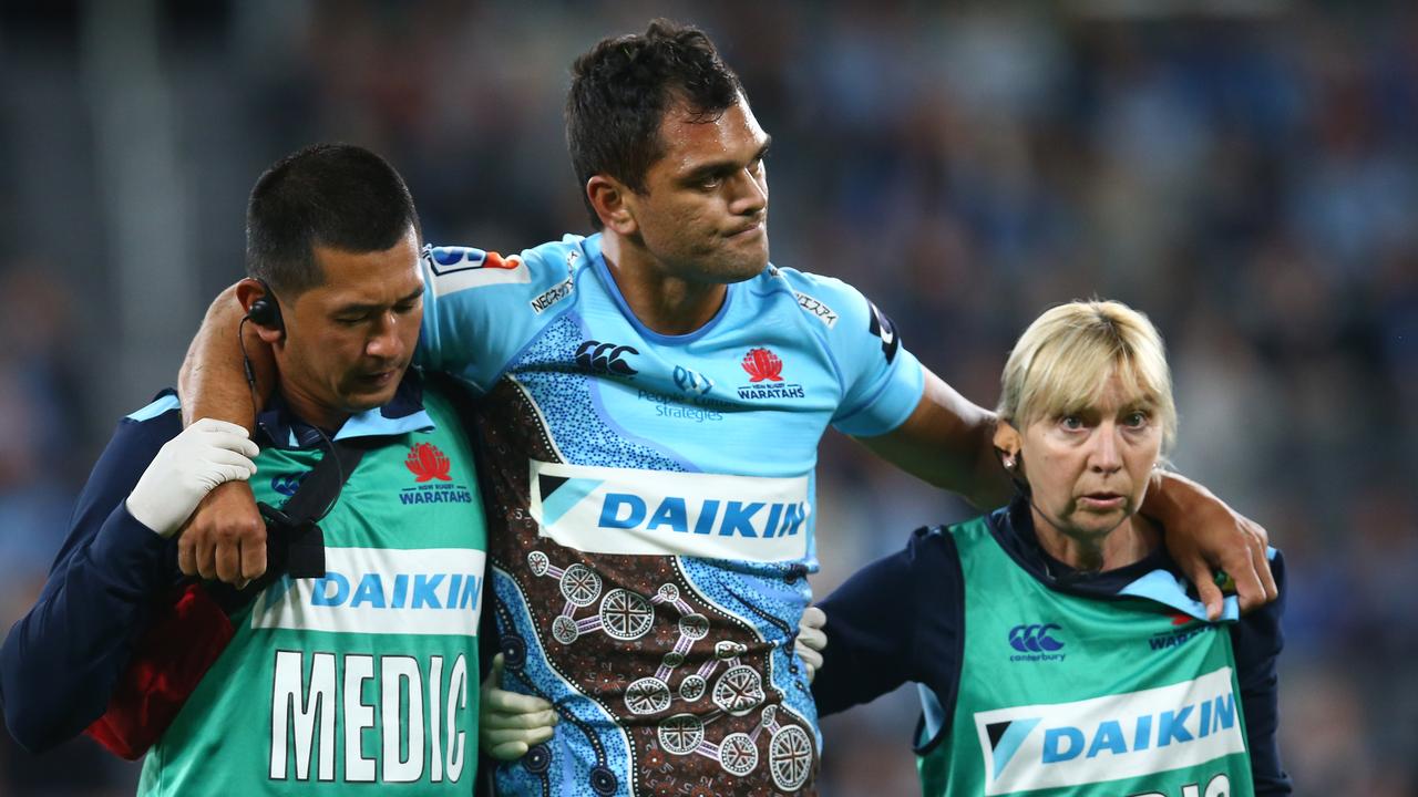 Karmichael Hunt of the Waratahs is assisted from the field injured against the Jaguares at Bankwest Stadium.
