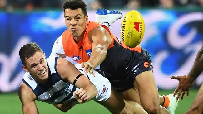 Geelong’s Joel Selwood gets a handball away under pressure from GWS’s Dylan Shiel on Friday night.