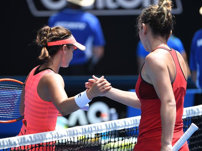 The battle won: Simona Halep (right) is congratulated by Lauren Davis. Picture: AFP