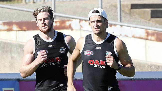 Port Adelaide co-captain Tom Jonas (left) hits the training track with injured teammate Ryan Burton. Picture: SARAH REED.