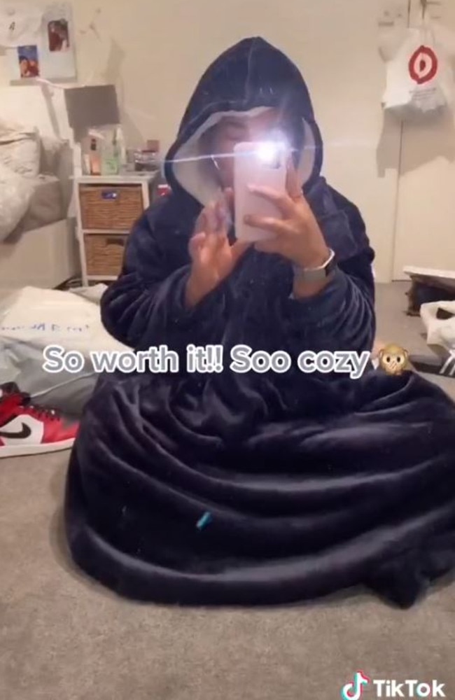 A Kmart shopper has found its $29 version of the expensive hooded blanket in navy blue. Picture: TikTok/@yaasssminee