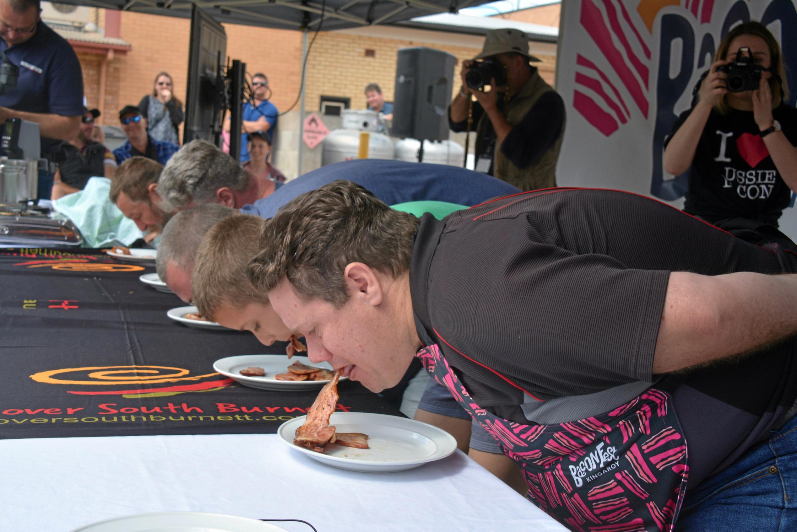 BACON: Competitors fight for the top spot at the bacon eating competition during Kingaroy's BaconFest on Saturday August 25. Picture: Jessica McGrath