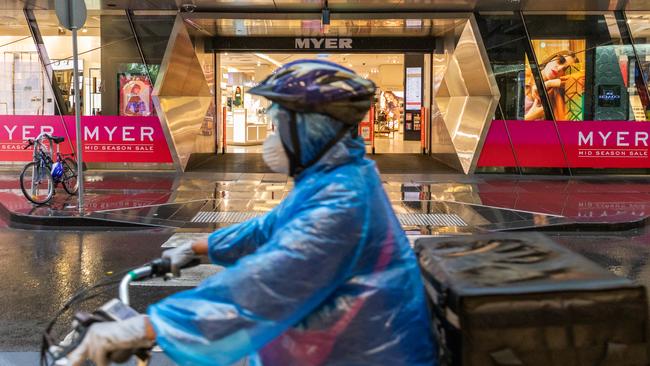 A food delivery driver wearing a face mask rides past a Myer on Bourke Street in the Melbourne CBD, Victoria. Picture: Getty Images