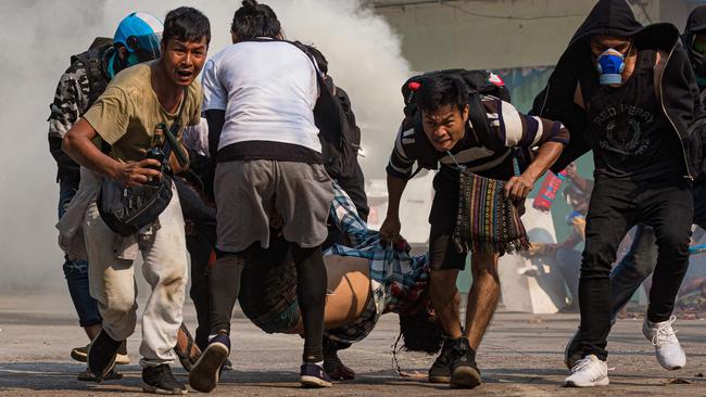 Protesters carry a wounded comrade shot with live rounds by security forces in Yangon on Wednesday. Picture: AFP